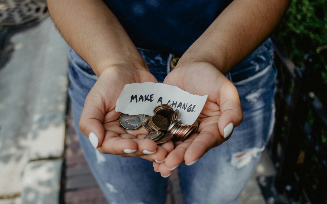 person showing both hands with make a change note and coins